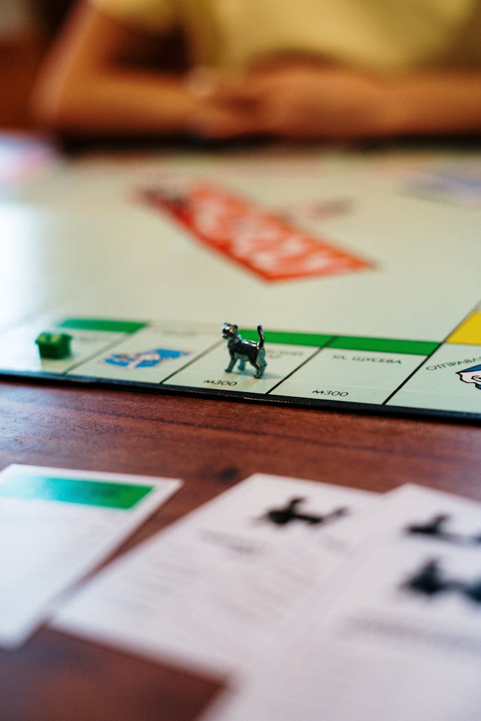 Monopoly board with game pieces, cards, in focus. Ideal for leisure and strategy concepts.